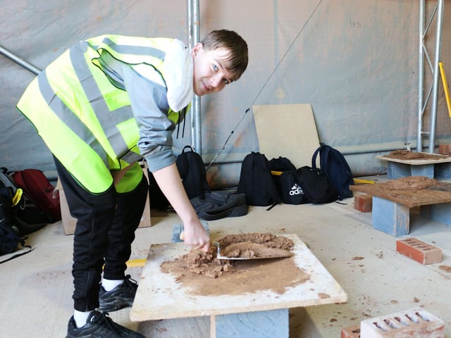 Daniel Wetton practices loading a trowel in the brickwork department