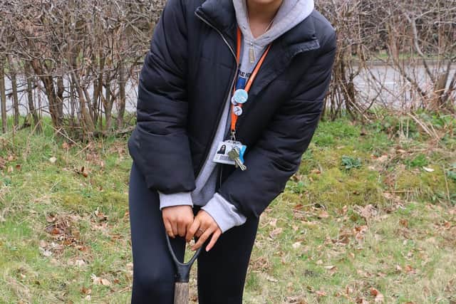 Zoe Gibson digs the first hole for the hawthorn saplings.