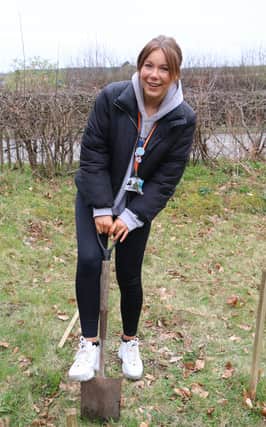 Zoe Gibson digs the first hole for the hawthorn saplings.