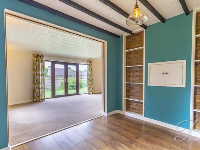 The dining area is an attractive space, with its wooden beams.and hatch through to the kitchen.