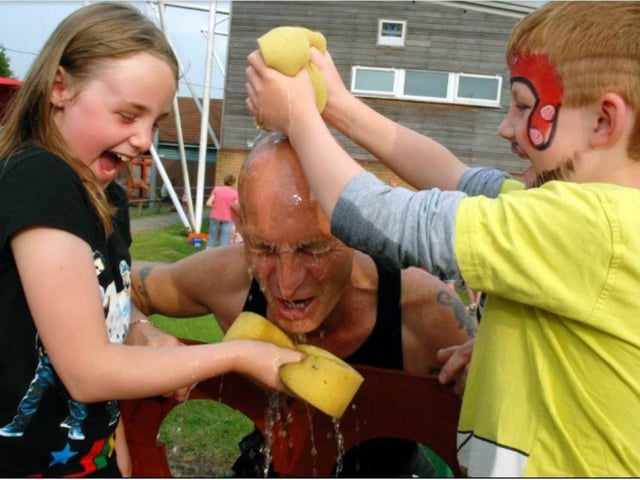 Site manager Steve Wright gets a soaking in the stocks from Jodie and Krystian Lees at Mansfield's Crescent Primary School summer fair.