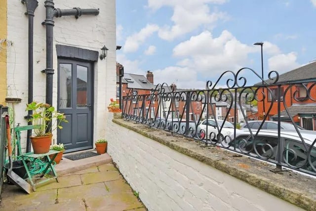 Outside, there is a forecourt with wrought iron railings and a gate to the front door. At the rear, there is a flagged terrace with gated access.