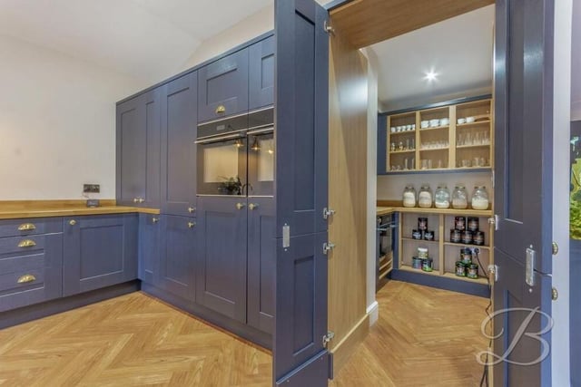 Just off the kitchen is this hidden, but spacious, pantry, which adds a touch of sophistication. It comes complete with an additional oven and sink.