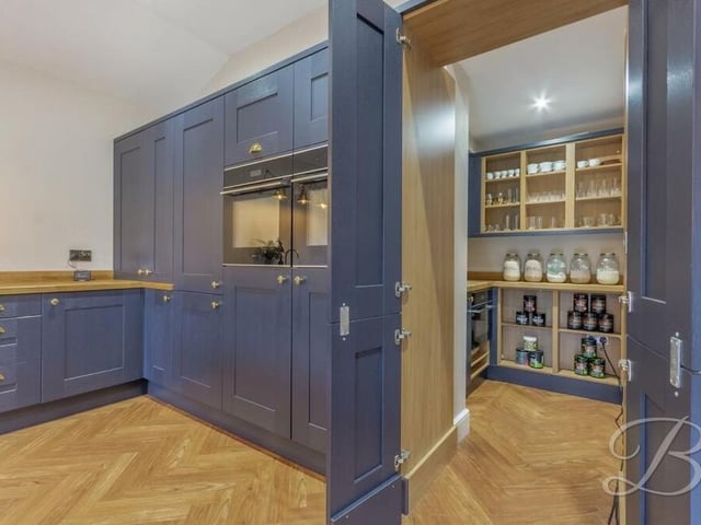 Just off the kitchen is this hidden, but spacious, pantry, which adds a touch of sophistication. It comes complete with an additional oven and sink.