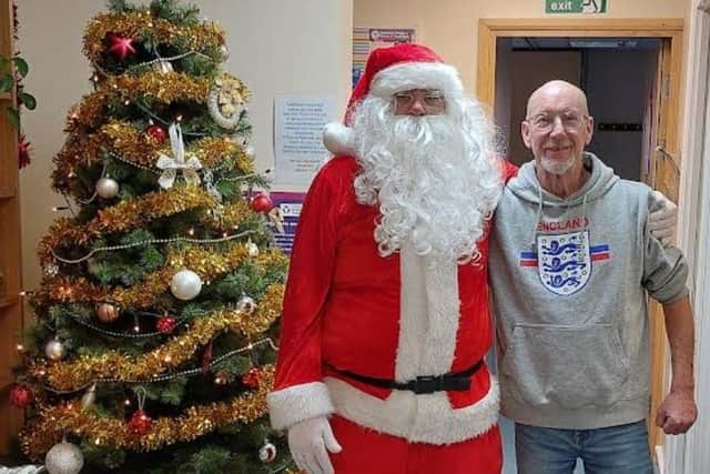 Santa meets volunteer Steve on a visit to the food bank before Christmas. Photo: Submitted