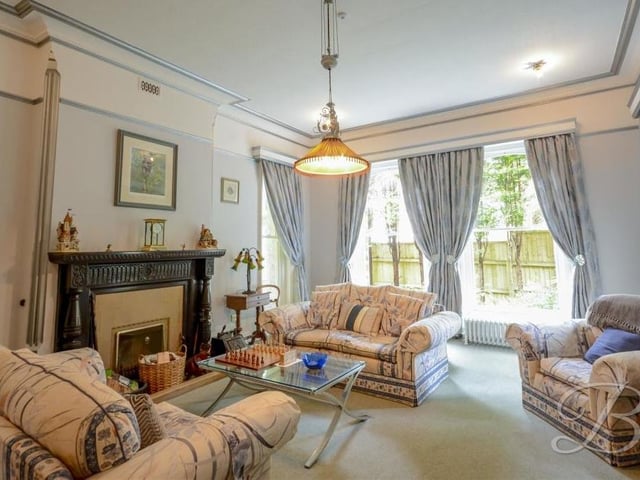 Let's move on now to the drawing room, which is bright and cosy. Another feature open fireplace stands out, as do four windows that look out on the back and side of the property and also to the orangery.