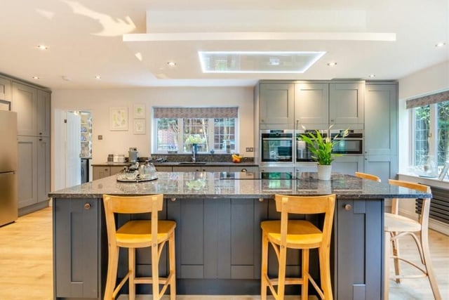 The kitchen's central island is so flexible. As well as the integrated induction hob, it boasts further base units and drawers, including pan drawers, and a granite worktop. There are windows to the side and back, plus French doors that lead out to the garden.