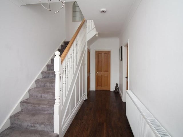 Before we move upstairs to the first floor, let's take a look at the entrance hall, with its textured wooden flooring. There is a storage cupboard underneath the stairs.