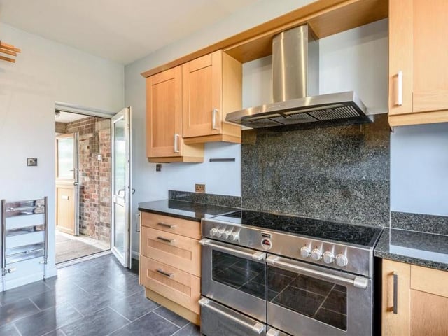 Another shot of the impressive kitchen, with a door leading to the rear lobby. Electric underfloor heating and ceiling downlights add to its appeal.