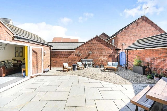 Our final photo shows the enclosed back garden, with French doors leading into the garage/bar. It has been designed with minimal fuss to the property owner, and features a modern and large paved patio area. The rest is gravelled, with gated access.