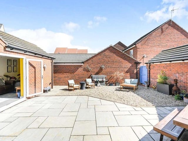 Our final photo shows the enclosed back garden, with French doors leading into the garage/bar. It has been designed with minimal fuss to the property owner, and features a modern and large paved patio area. The rest is gravelled, with gated access.