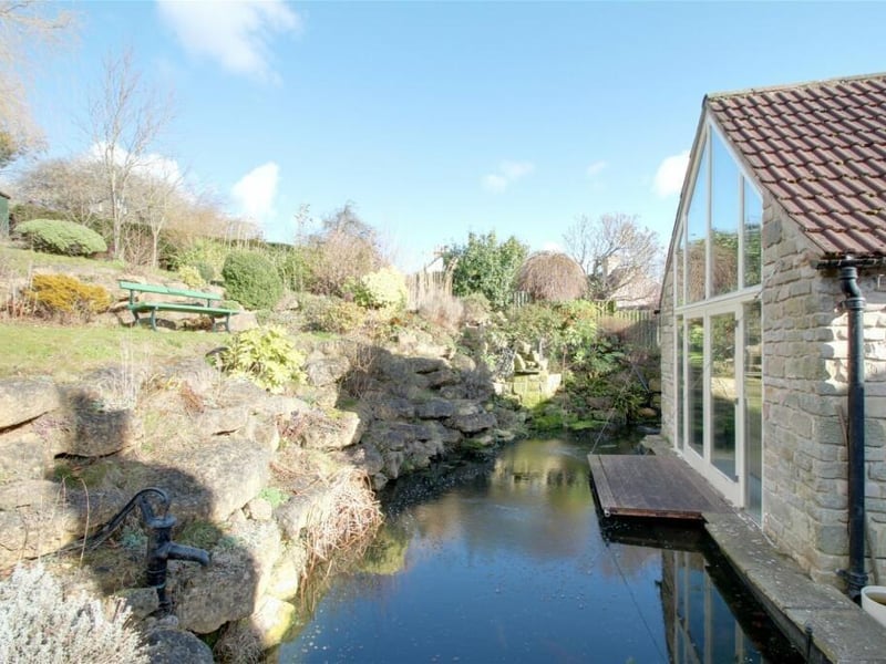 The exterior of the property is as attractive as the interior, with no better example than this delightful pond as it runs by the garden room.