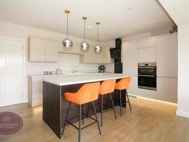 Integrated appliances in the kitchen include a double electric oven and hob with extractor over, a full-length fridge, under-counter freezer, washing machine and dishwasher.