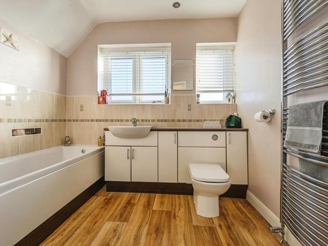The first floor houses this modern, fully-fitted family bathroom. A four-piece suite comprises a large ceramic bath, ceramic toilet and sink set in a vanity unit with storage and worktop space, and also a sizeable walk-in shower that runs off the mains, Added bonuses are spotlights, a wall-fitted towel-radiator, vinyl flooring and tiled splashbacks.