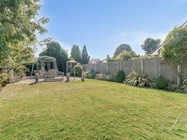 It's time to step outside now, with the rear garden our first port of call. Fully enclosed, it features a sizeable, neat lawn, with planted borders.