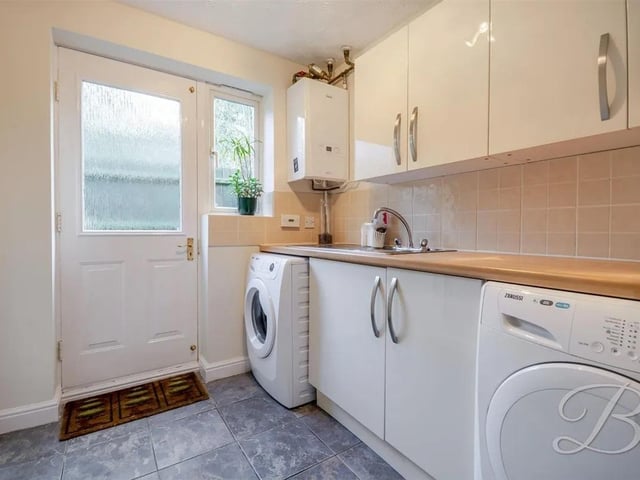The dedicated utility area has inset sink and storage cupboards space for appliances and window to the side elevation.