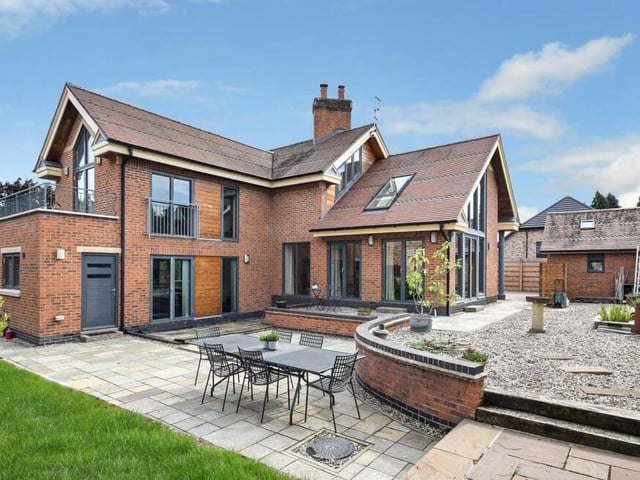 Time to step outside now, and to take a look at the property from the rear. You can see the balconies and feature windows, also a nicely designed garden that has multiple, defined seating areas and patios, as well as a lawn.