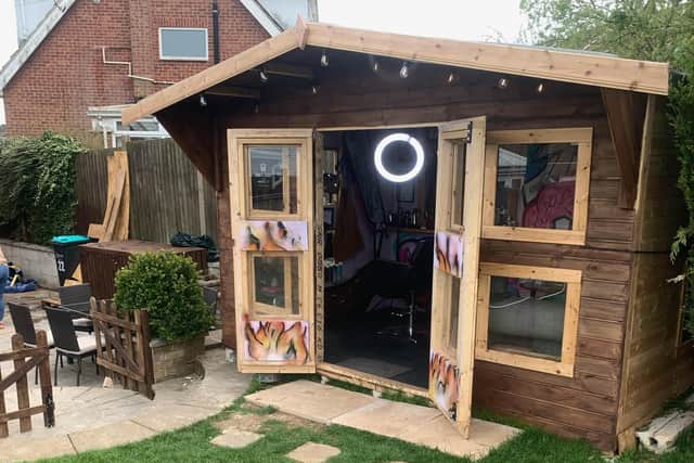 The welcoming exterior of Aidan's Fade House summer house-turned-barber's shop in his back garden.