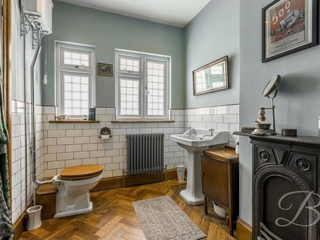 The days of stepping out of the bath and shivering in front of a warm fire are long gone, but the cast-iron fireplace adds charm to this distinctive family bathroom on the first floor. It also features a pedestal sink, high-flush WC and parquet flooring.