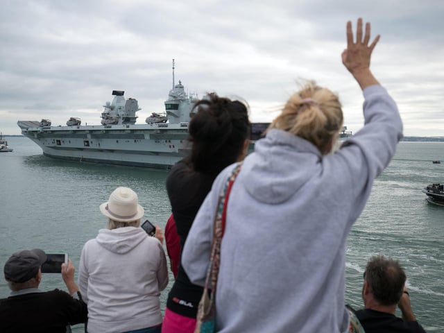 People wave from the Round Tower in Old Portsmouth as HMS Queen Elizabeth departs. Picture: Andrew Matthews/PA Wire