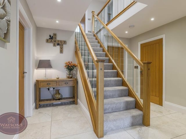 As we prepare to move up to the first floor, let's pass through the welcoming entrance hall and climb the oak staircase.