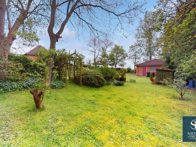 The splendid garden is filled with mature trees and shrubs.