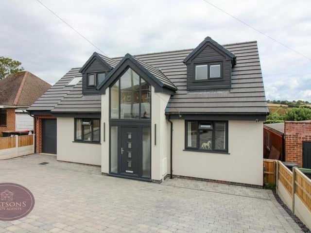 Let's step outside now and return to the front of the house, where a block-paved driveway provides ample off-street parking space and leads a garage with electric roll-up door and power.