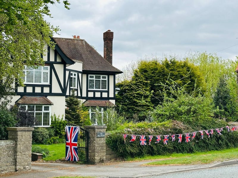 Properties along the A60, across from The Carrs, are adorned with flags and bunting to enhance the display.