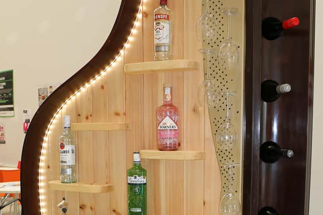 The custom-made drinks cabinet boasts shelving, a wine rack, glass-holders, bottle opener and contemporary lighting.