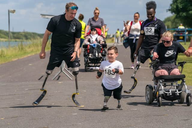 Richard Whitehead runs alongside young participants.