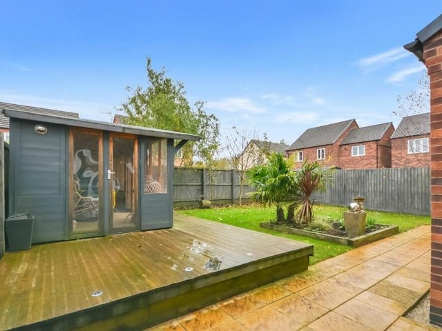 The back garden at the £365,000 house also features this well-constructed summer house on raised decking.