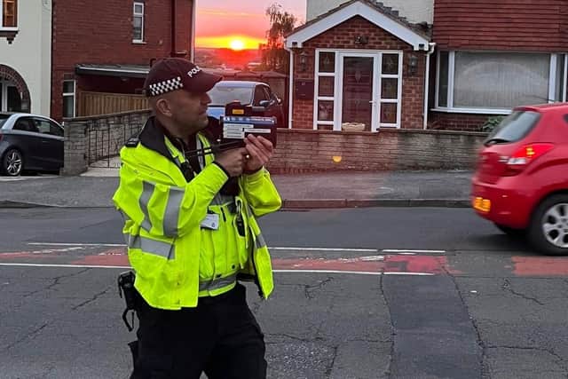 A police officr operates a RADAR gun.
