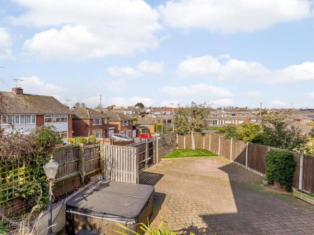 A bird's eye view of the back of the property. There is an artificial turf area at the end of the plot, with fenced boundaries to all sides.