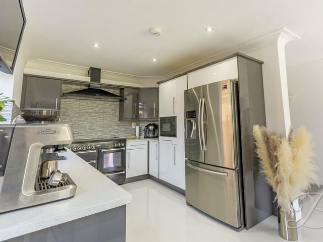 The kitchen/diner is fitted with an extensive range of modern gloss wall and base units with granite worktop over, inset sink and drainer. Appliances include a Rangemaster cooker set with extractor fan, an integrated microwave and an integrated dishwasher. There is space for a double fridge/freezer.