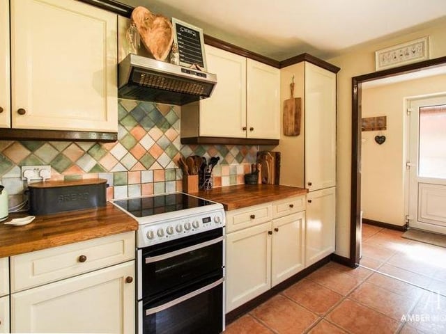 The living room/diner leads on to the kitchen at the back of the house. It is fitted with a range of base, wall and drawer units with work surfaces over. A free-standing cooker, with four-ring gas hob and extractor over, fits in well.