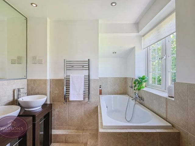 The modern ensuite four piece suite comprises wc, twin vanity sink, panel bath and mains fed cubicle shower.