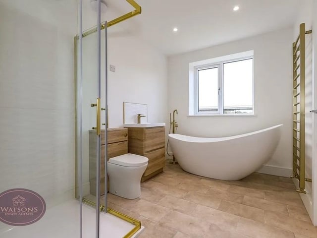 White 4 piece suite comprising; concealed cistern wc, vanity sink unit, freestanding bath and double shower cubicle with mains fed rainfall shower. Obscured uPVC double glazed window to the rear, chrome heated towel rail and ceiling spotlights.