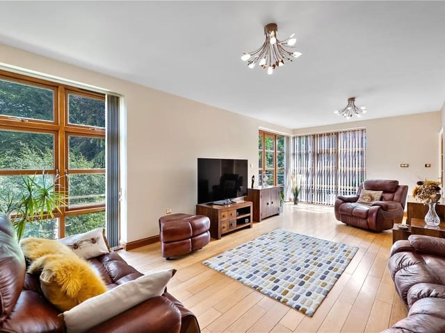 The lounge boasts floor length windows to the side and rear aspects, with doors leading onto the veranda.