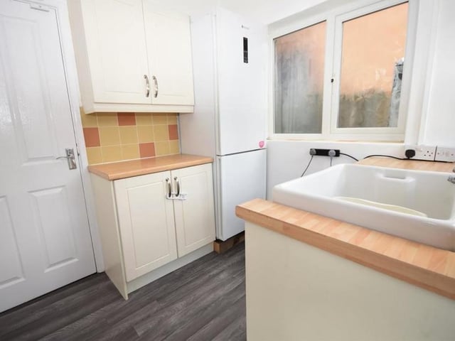 This utility room is conveniently placed close to the kitchen. Wall and base units offer extra storage, while there is also a practical Butler sink with tiled splashback. A door gives access to the garage.
