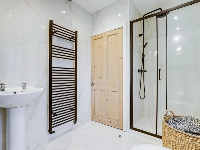 The modern family bathroom features a bath and separate rainfall shower - the perfect place to rest and relax.