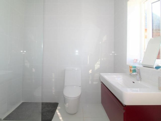 The en suite shower room to the main bedroom/living room on the first floor. It comprises a shower cubicle, low-flush WC and wash hand basin.