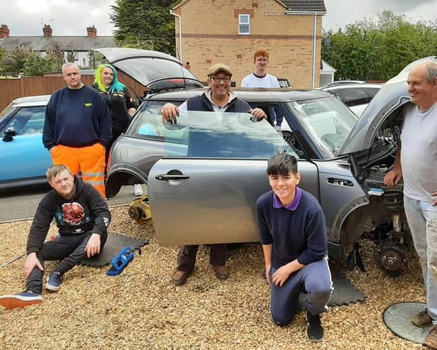 Mini enthusiasts working on the car at the Huthwaite home of Chris Miller.