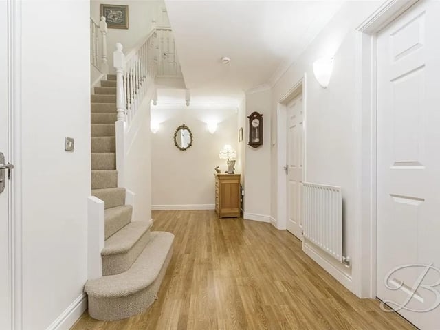 A grand entrance awaits with laminate flooring, built in storage cupboard and stairs rising to the first floor.