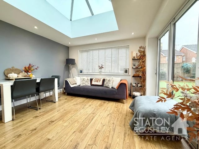 The relaxed open plan snug/dining area has a stunning ceiling lantern that floods the space with natural light