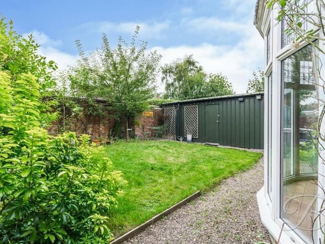 At the back of the house sits this delightful walled garden, with lawn and gravel.