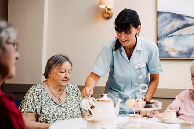 Carer pours tea for resident at Newgate Lodge Care Home.
