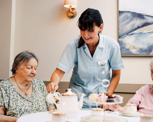 Carer pours tea for resident at Newgate Lodge Care Home.