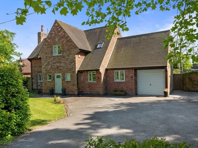 The impressive house with striking character appeal is beautifully positioned in its wide corner plot of approximately a fifth of an acre. Privacy hedge screening fronts a lawned garden edged with mature trees, and a traditional-style lamppost adds a touch of charm alongside contemporary exterior courtesy lighting. An attached garage complements the house, and the generous driveway provides plenty of parking for multiple vehicles.