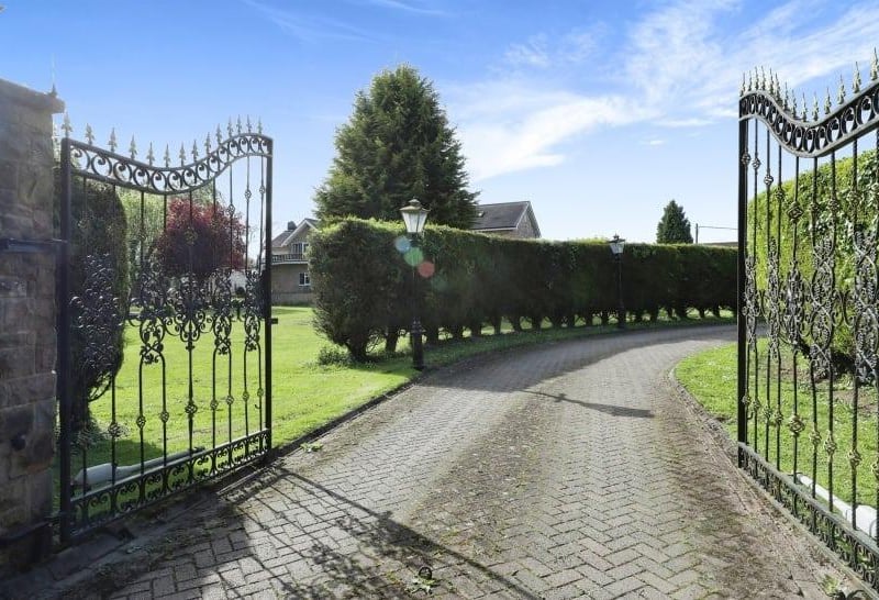 Majestic electric gates, which are served by an intercom system, open on to a large, private driveway that leads to all three properties. The winding driveway is lined by Victorian street lanterns that work on sensors, and also by tall conifer trees.