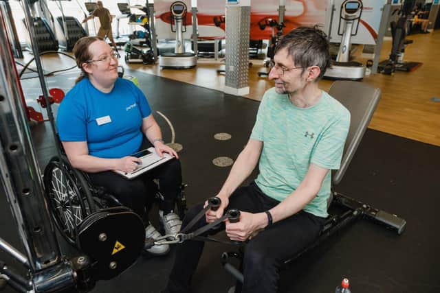 An instructor looking after someone in the gym